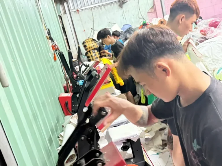 Kỹ thuật viên in ép logo lên áo thun quà tặng tại xưởng